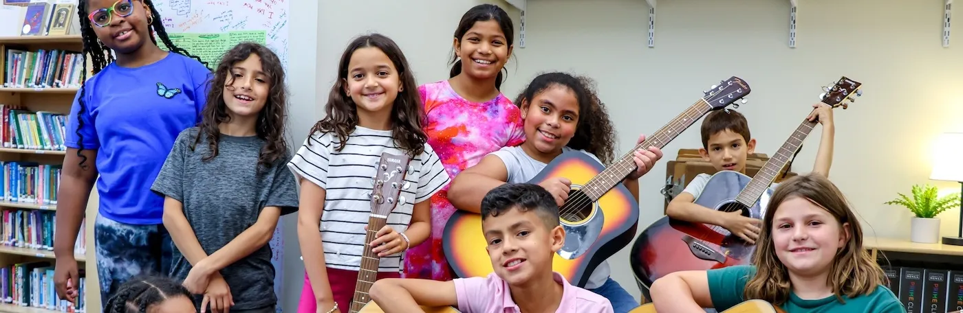 students smiling with guitars